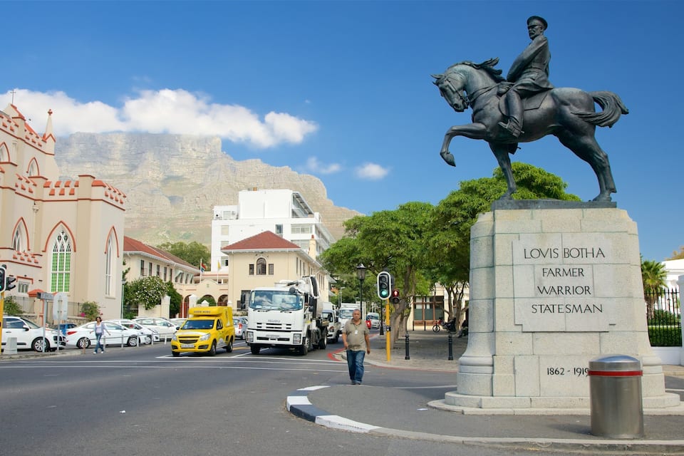 A statue of a man on a horse, a church, and a mountain in the background.