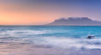Un paisaje costero con una montaña destacada y olas del océano.