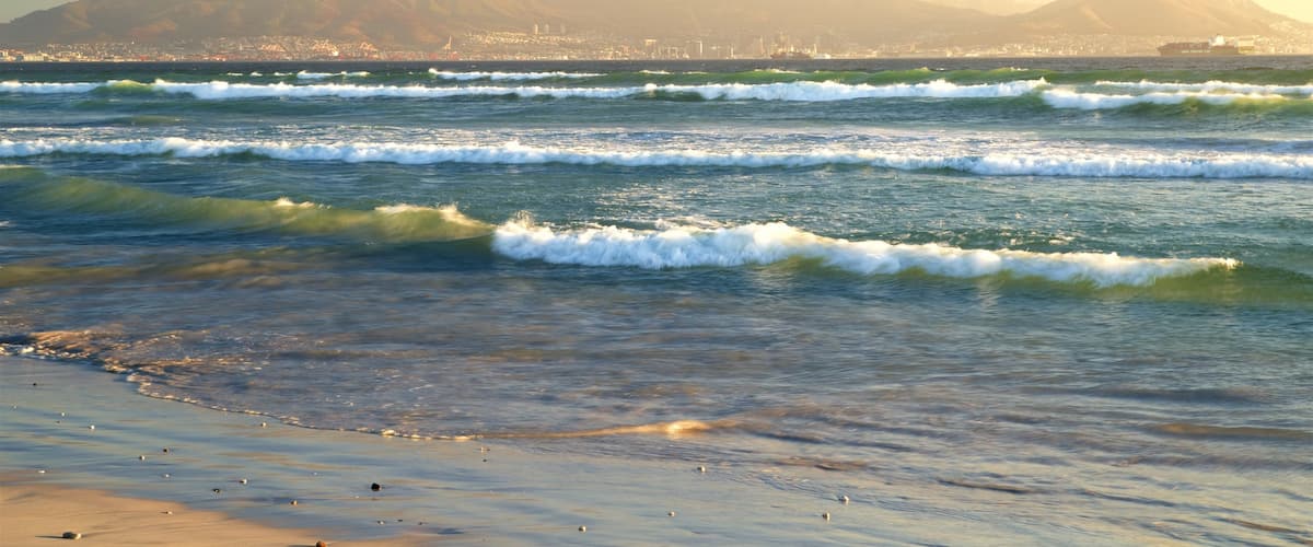 Ciudad del Cabo que incluye una playa, un atardecer y surf