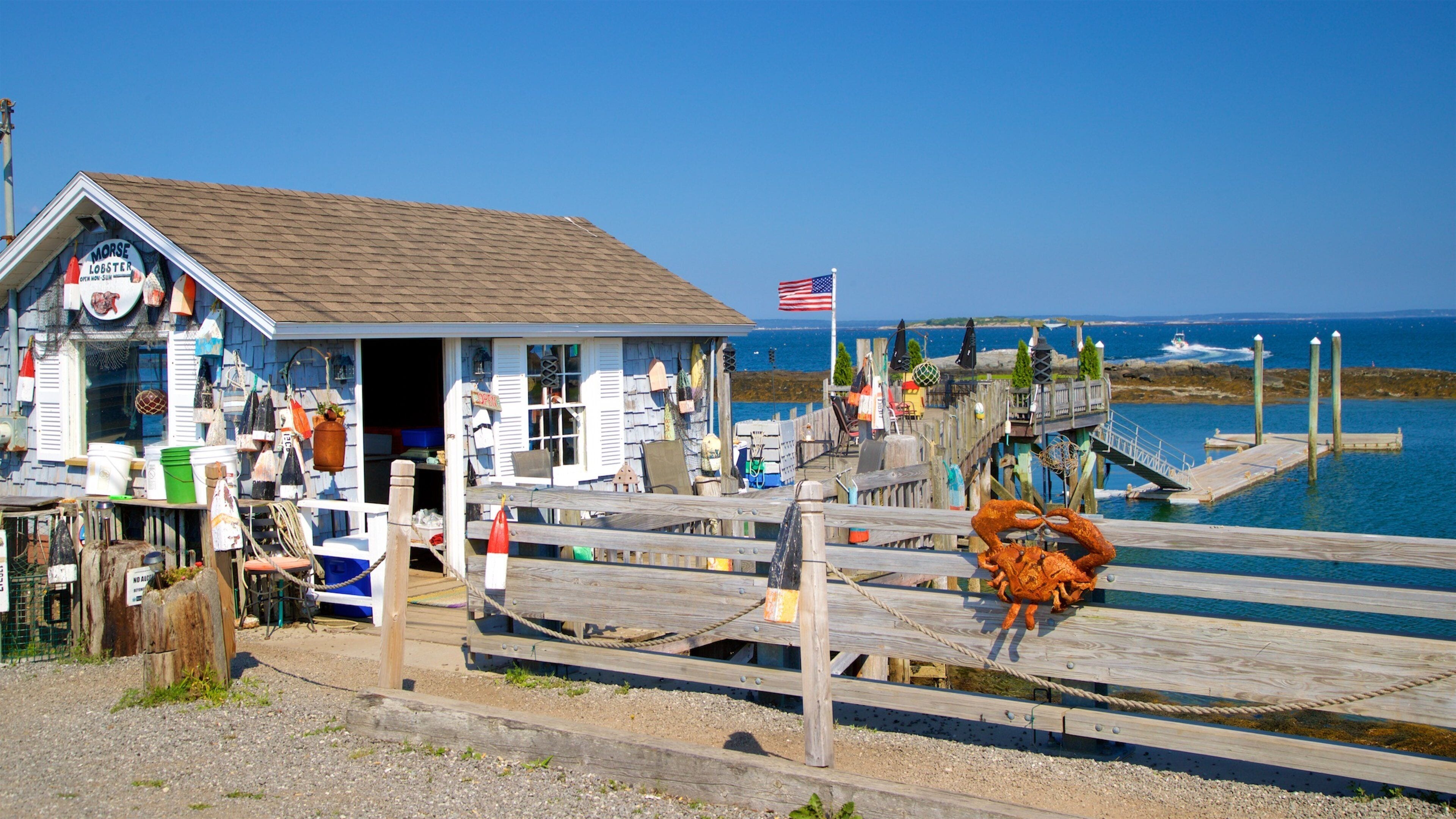 A coastal building with a sign reading "MORSE LOBSTER" and a wooden pier extending into the water.