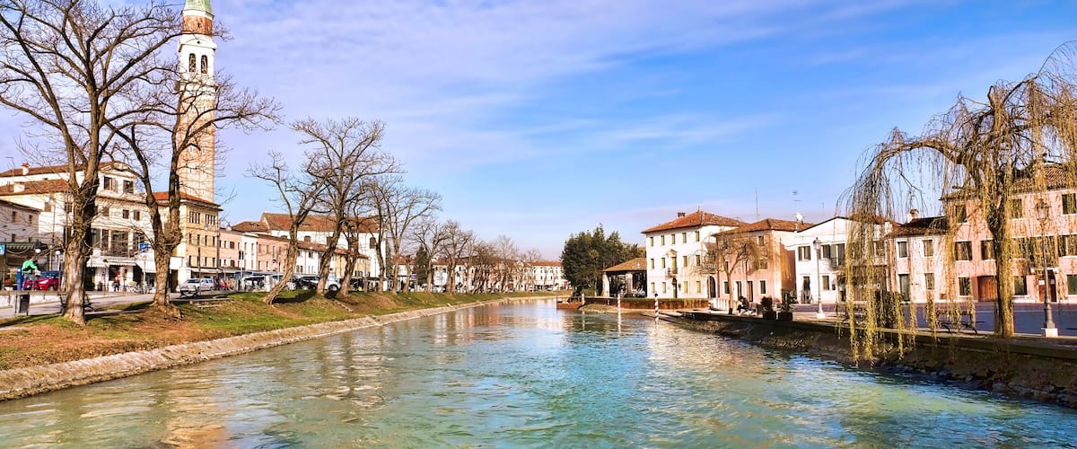 A river with buildings and a tower on the left.