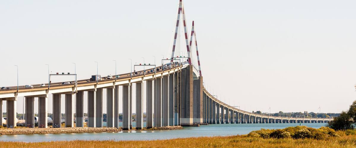 A large bridge with multiple lanes of traffic, spanning over a body of water.
