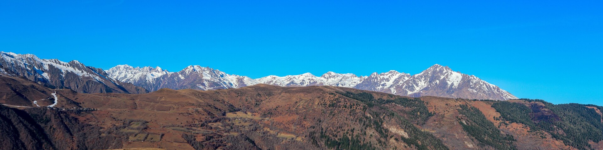 Cordillera con picos nevados bajo un cielo azul despejado.