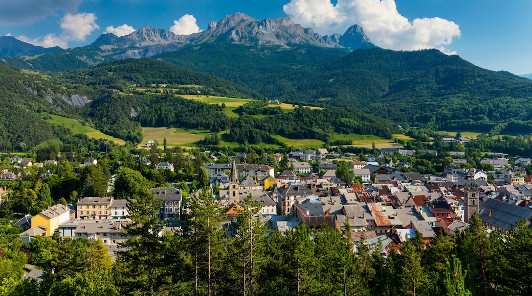 Une ville nichée dans une vallée, avec une chaßne de montagnes en arriÚre-plan.