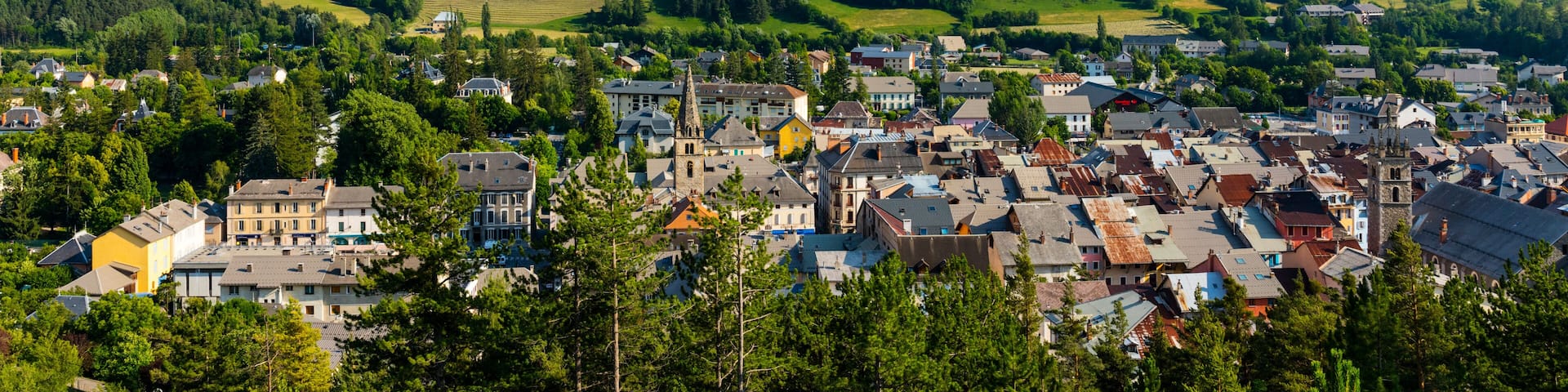 A town nestled in a valley with a mountain range in the background.