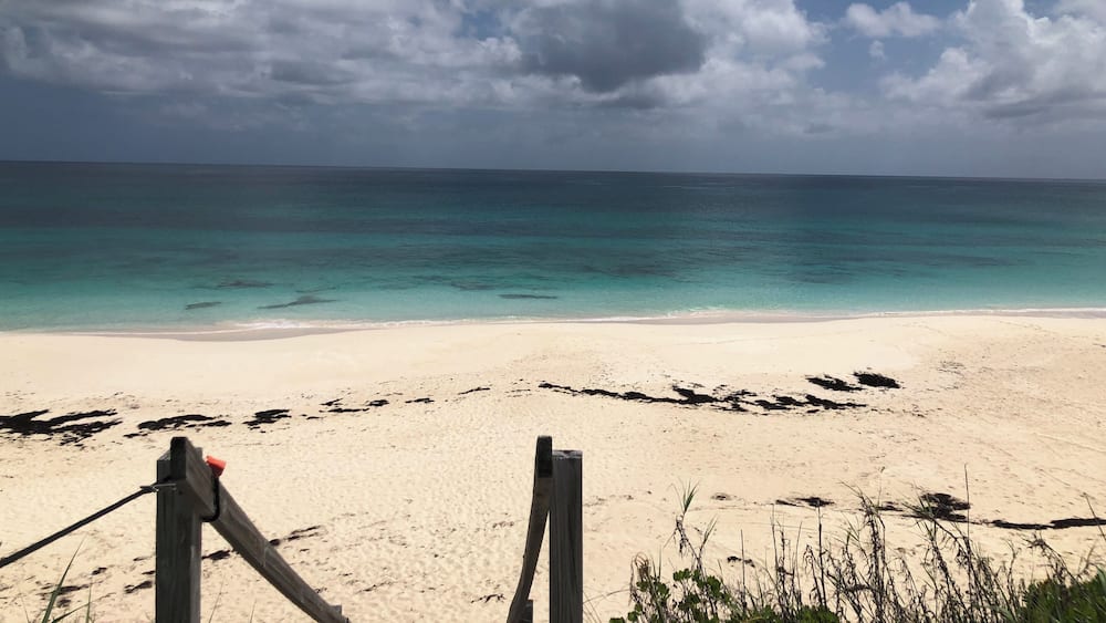 A beach with clear turquoise water and a sandy shore.