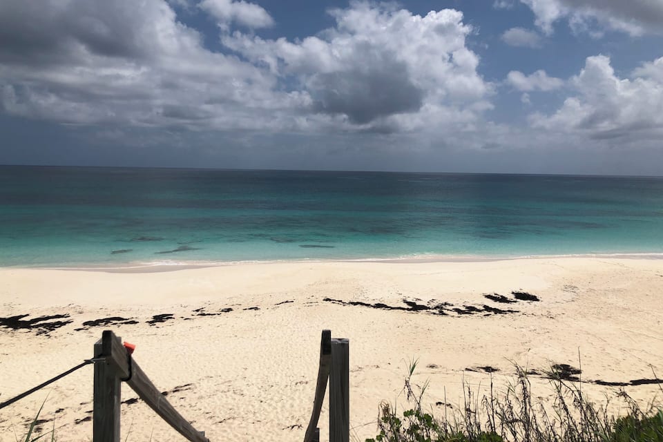 A beach with clear turquoise water and a sandy shore.