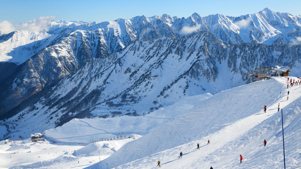 A snow-covered mountain slope with skiers and a ski lift.