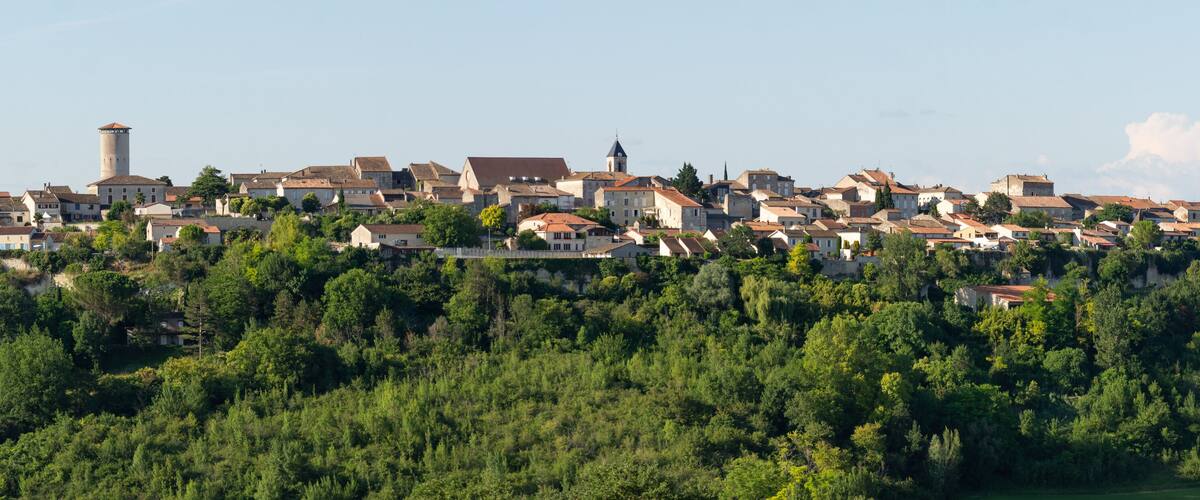 A hillside town with historic buildings and a prominent tower.