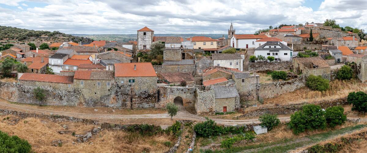 A historic town with stone buildings and a fortified wall.