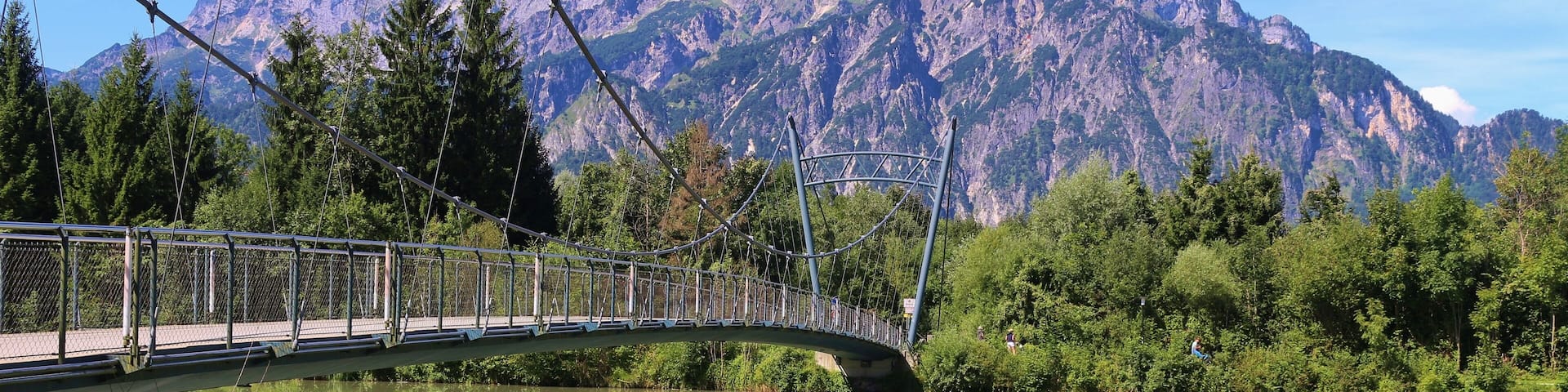 Pedestrian bridge over the Salzach river in Puch, not far from Salzburg city. In the background the mountain Untersberg. Puch, Austria, Europe.