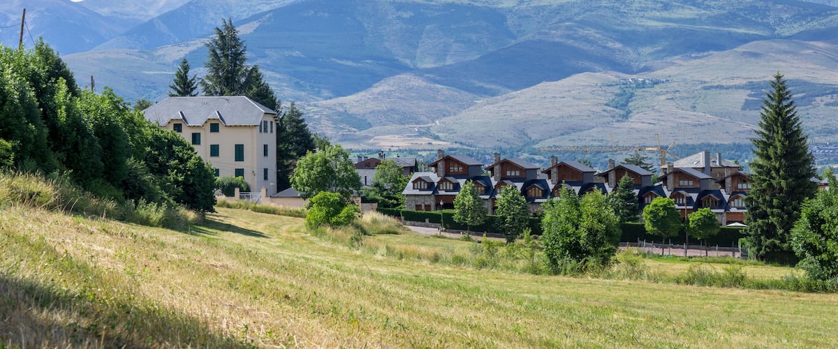 A residential area with houses and mountains in the background.