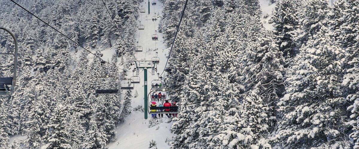 A ski lift with snow-covered trees and a clear sky.