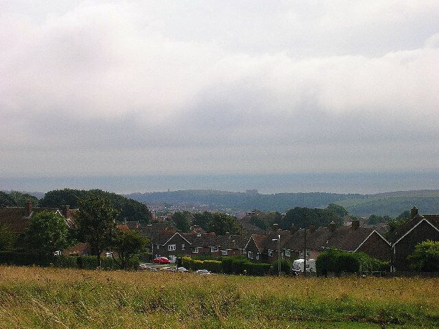 Woodingdean from Norton Drive. Looking south towards the sea. The two buildings in the centre of the picture next to the sea are St Dunstans (right), a centre for the blind, and Rottingdean windmill (left).