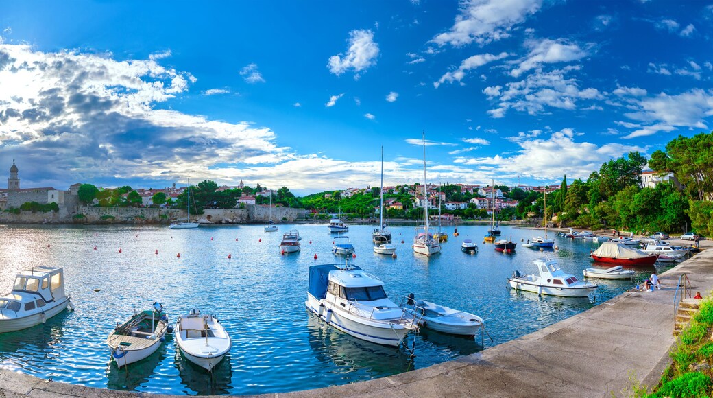 Wonderful romantic summer evening landscape panorama coastline Adriatic sea. Boats and yachts in harbor at cristal clear azure water. Old town of Krk on the island of Krk. Croatia. Europe.
