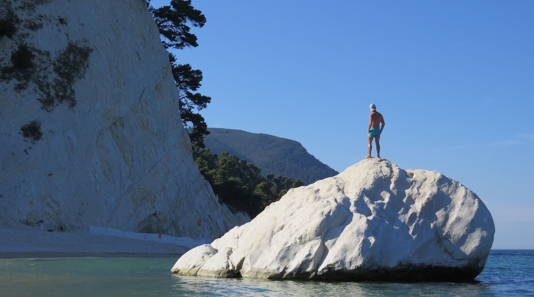 Beautiful pebble beach with white-faced rock cliffs.
