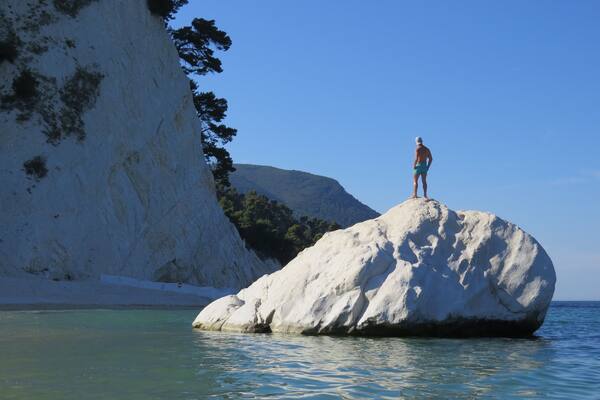 Beautiful pebble beach with white-faced rock cliffs.