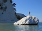 Beautiful pebble beach with white-faced rock cliffs.
