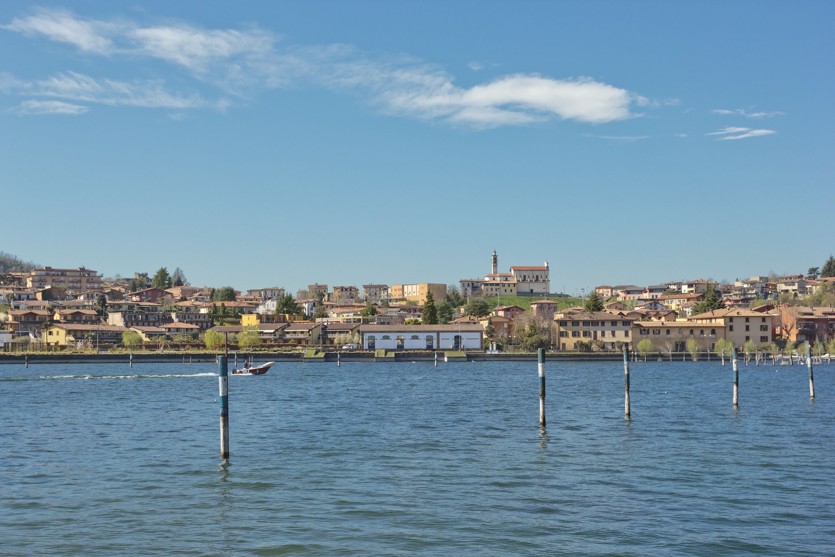 A calm lake with a cityscape in the background.