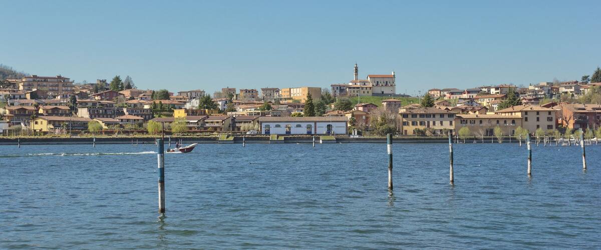 A calm lake with a cityscape in the background.