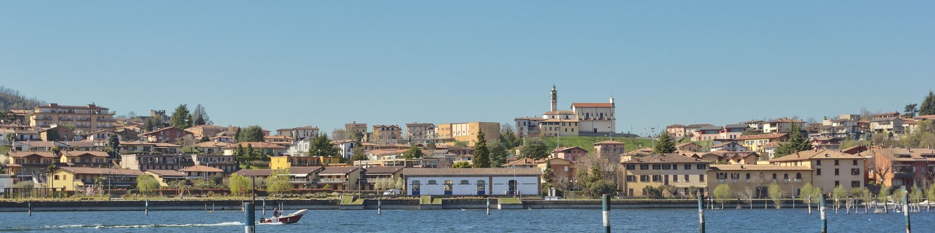 A calm lake with a cityscape in the background.