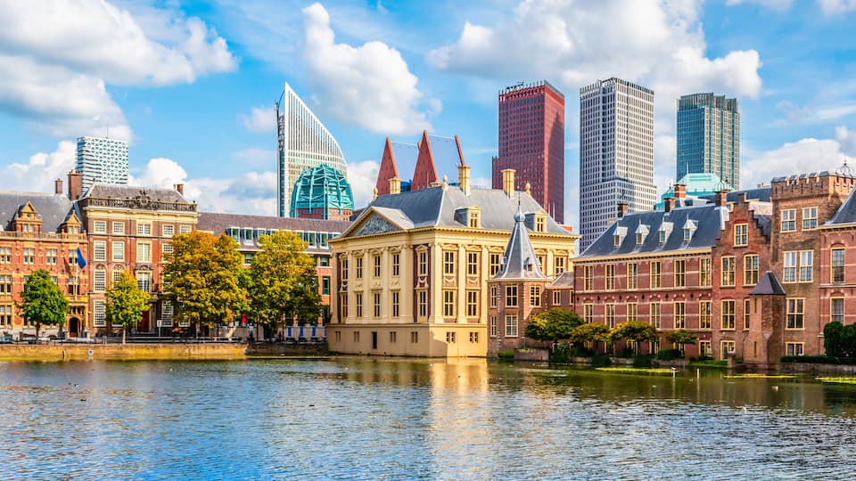A river with historic buildings and modern skyscrapers.
