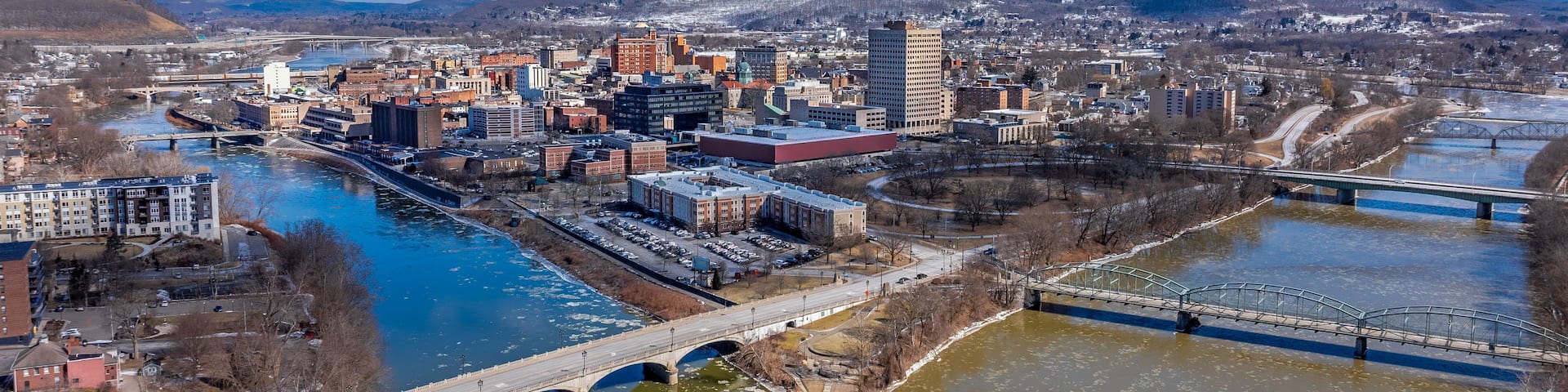 A cityscape with a river, bridges, and a snow-covered landscape.
