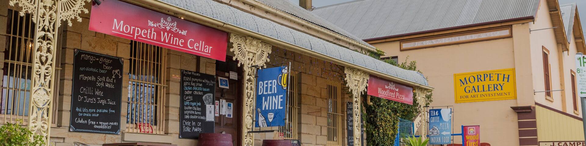 A building with signs for Morpeth Wine Cellar, Beer Wine, and Morpeth Gallery.