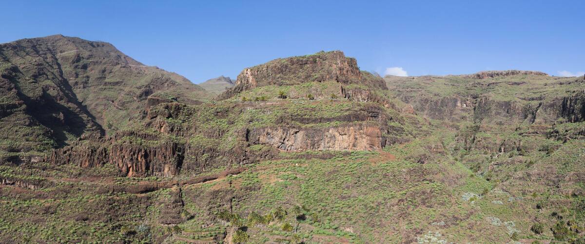 A mountainous landscape with rugged terrain and sparse vegetation.