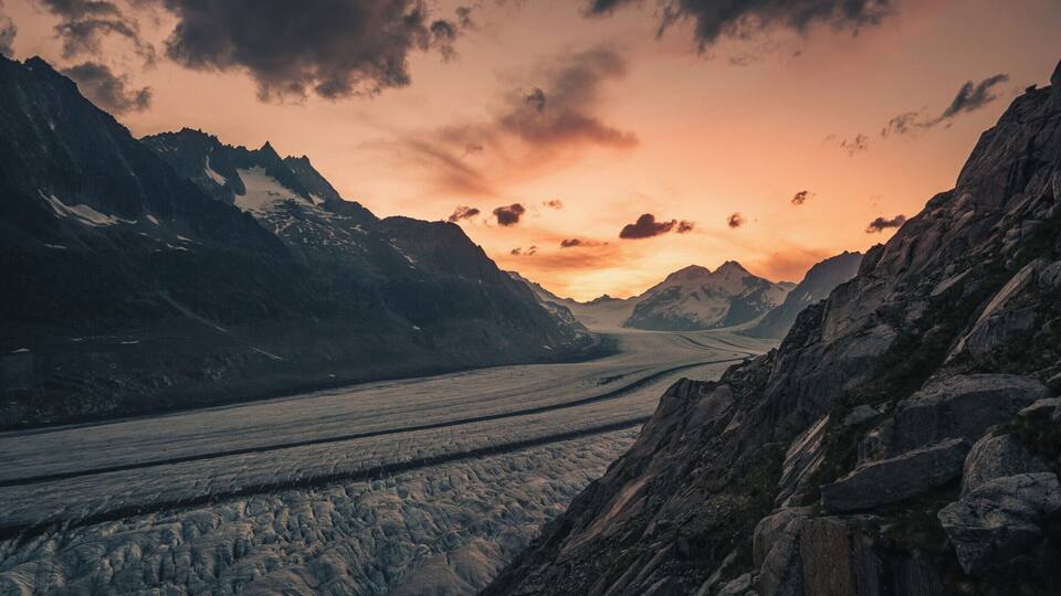 A glacier with rugged mountains in the background.