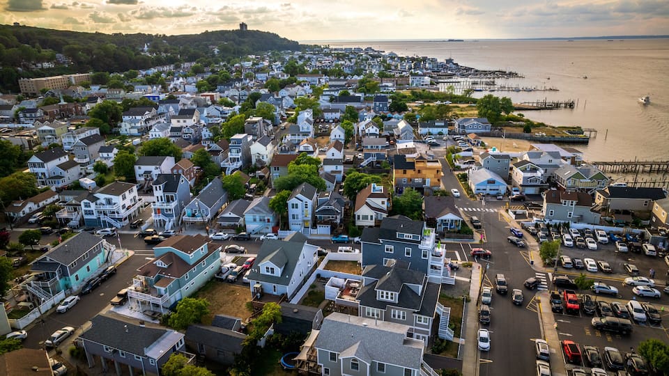 A coastal town with houses, a pier, and a body of water.
