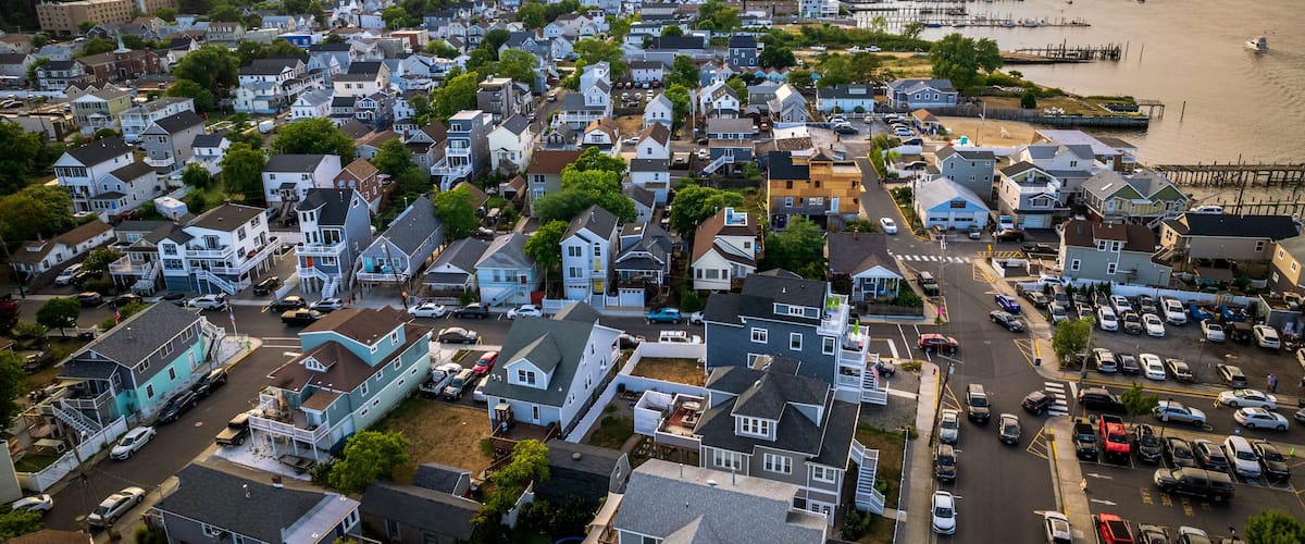 A coastal town with houses, a pier, and a body of water.