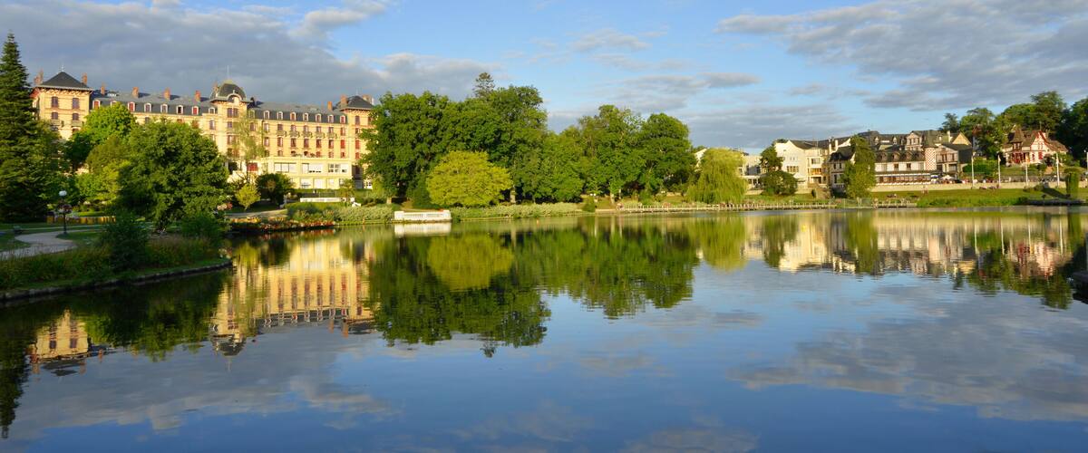 A calm lake reflecting buildings and trees.