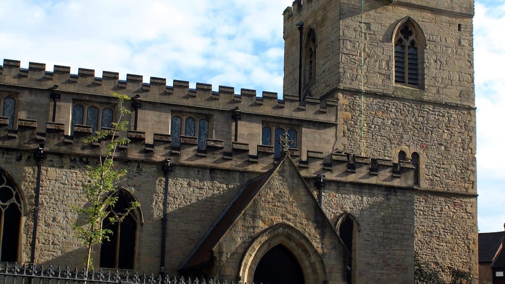 A historic stone building with a prominent tower and arched windows.