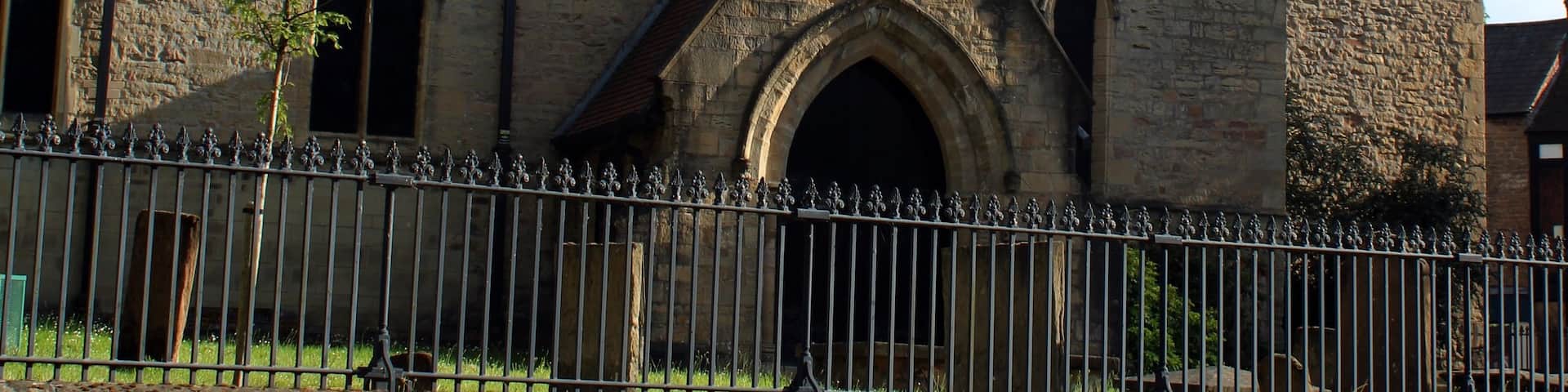 A historic stone building with a prominent tower and arched windows.