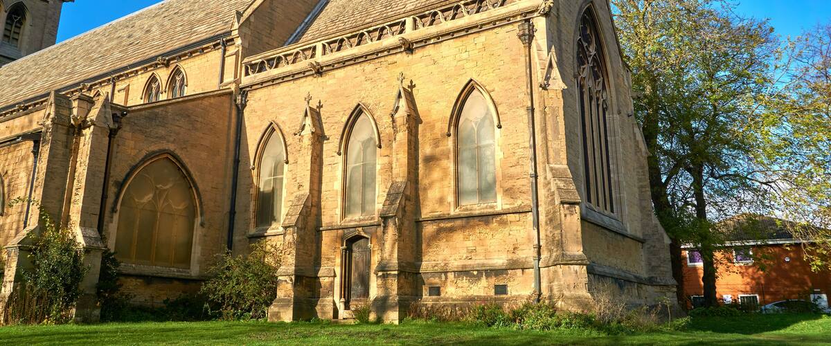 A historic church with large arched windows and a tall steeple.