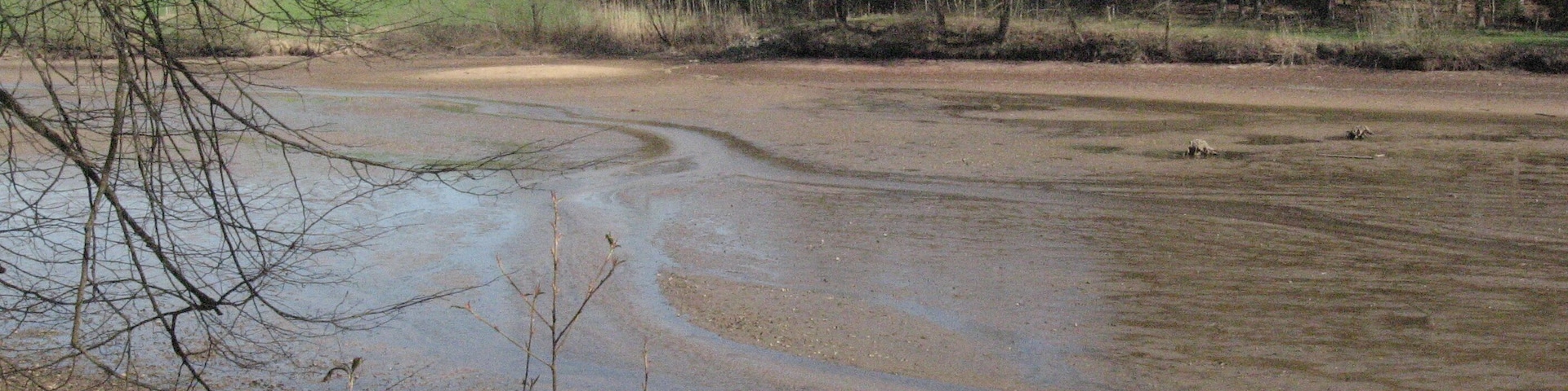 Blick nach NE über den oberen Glasweiher bei Ellwangen-Glassägmühle. Bei Niedrigwasser – ein Hinweisschild am See sprach von Durchspülen – fließt der Rotenbach in kleinen Strömungsrinnen auf dem sandigen Seegrund.