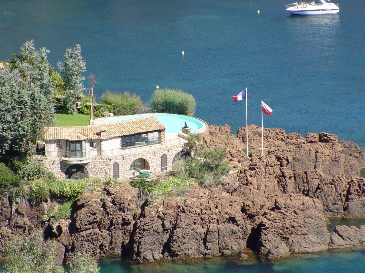 A stone house with a swimming pool on a rocky coastline.