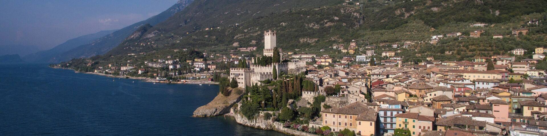Une ville côtière qui se distingue par son imposant château, son décor montagneux et son ciel d’un bleu limpide.