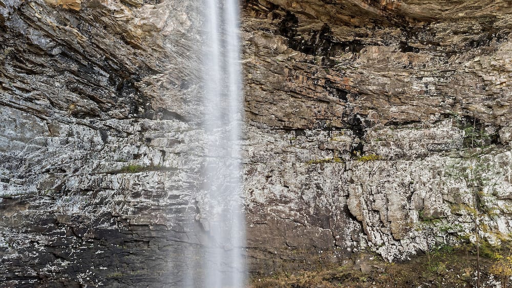 A waterfall cascading down a rocky cliff into a pool below.