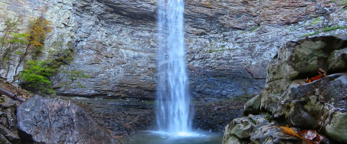 A waterfall cascading down a rocky cliff surrounded by trees.