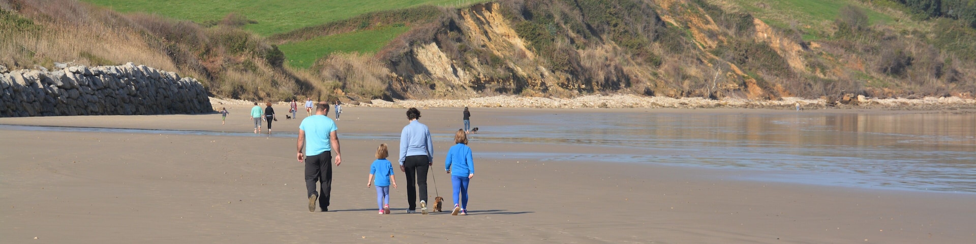 familia caminando por la playa