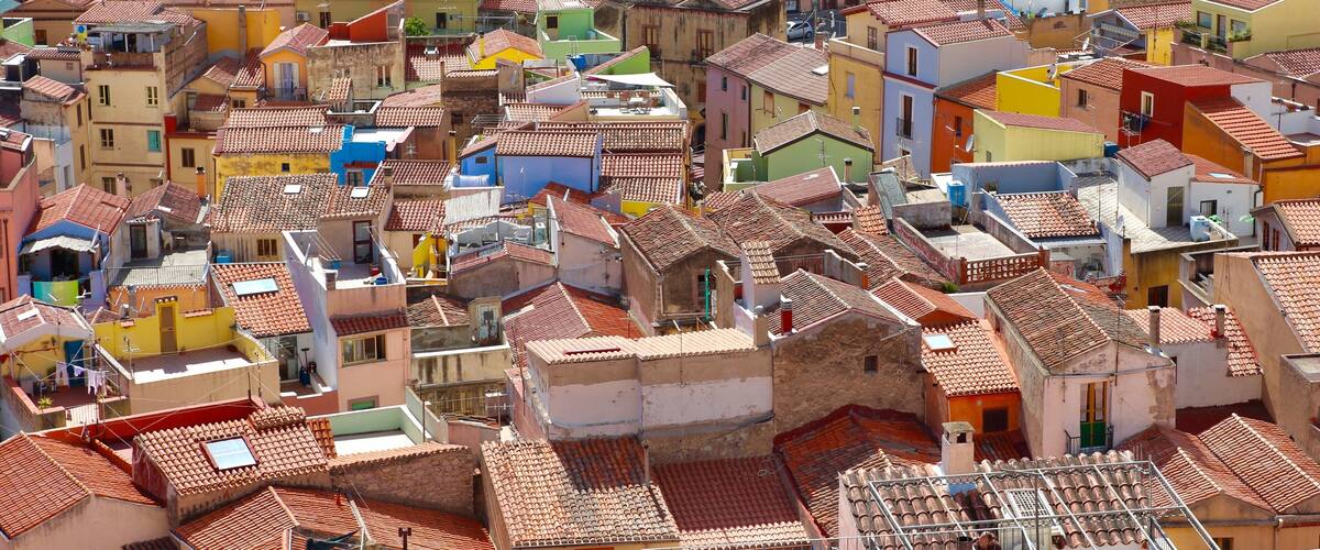 A densely packed urban area with colorful buildings and a narrow street.