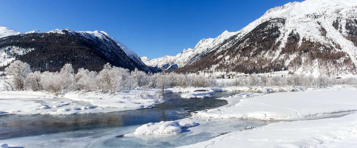 A snow-covered river with mountains in the background.
