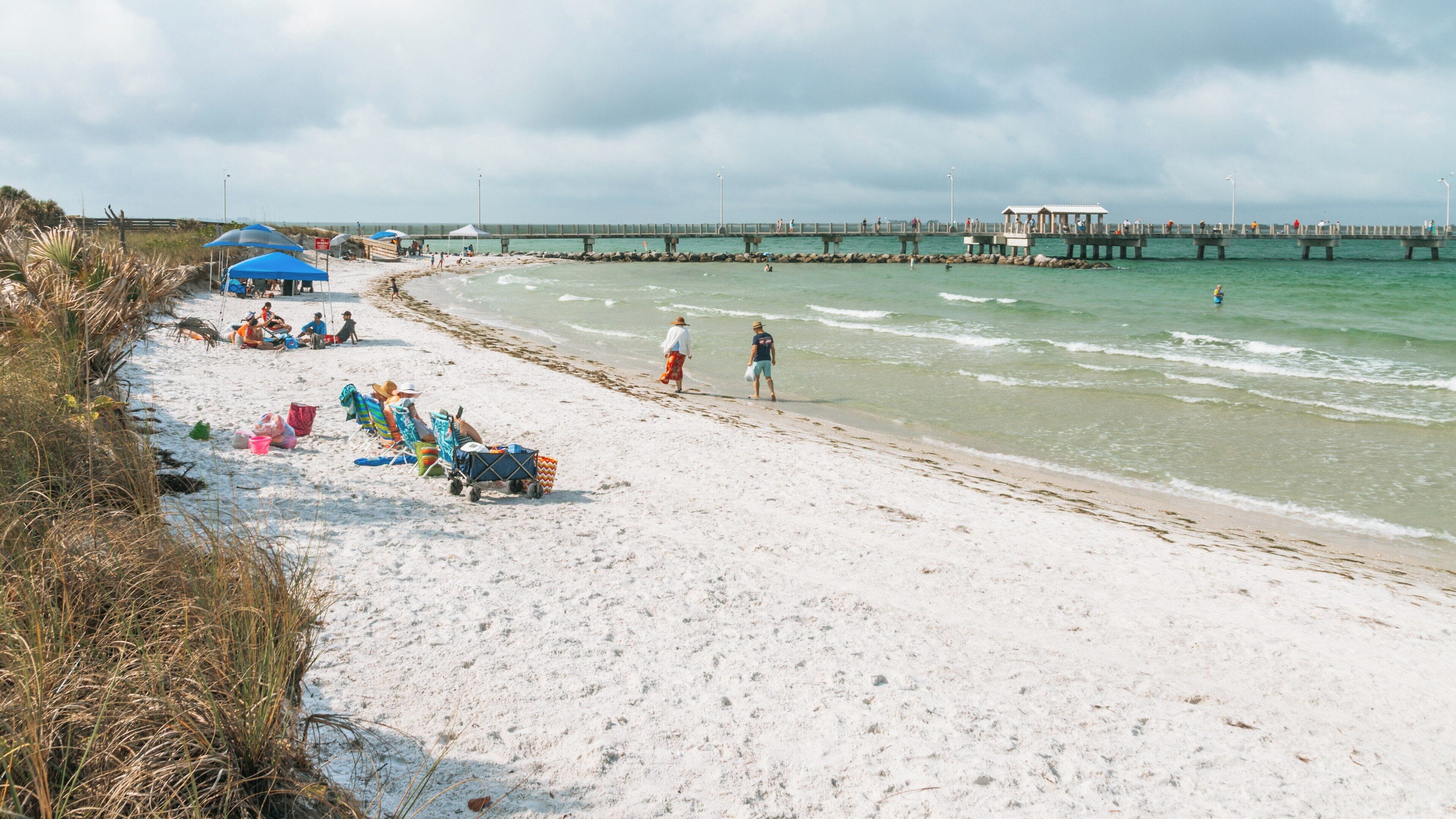 Enjoying a sunny day on the beach at Fort De Soto Park in St. Petersburg, Florida with families relaxing and walking along the shore
