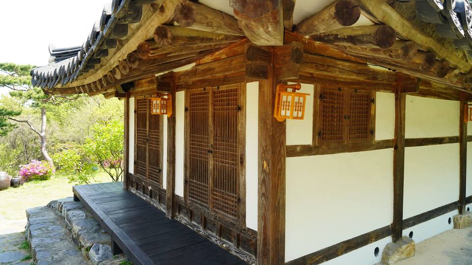 A traditional Japanese building with wooden beams, a tiled roof, and a stone pathway leading to the entrance.