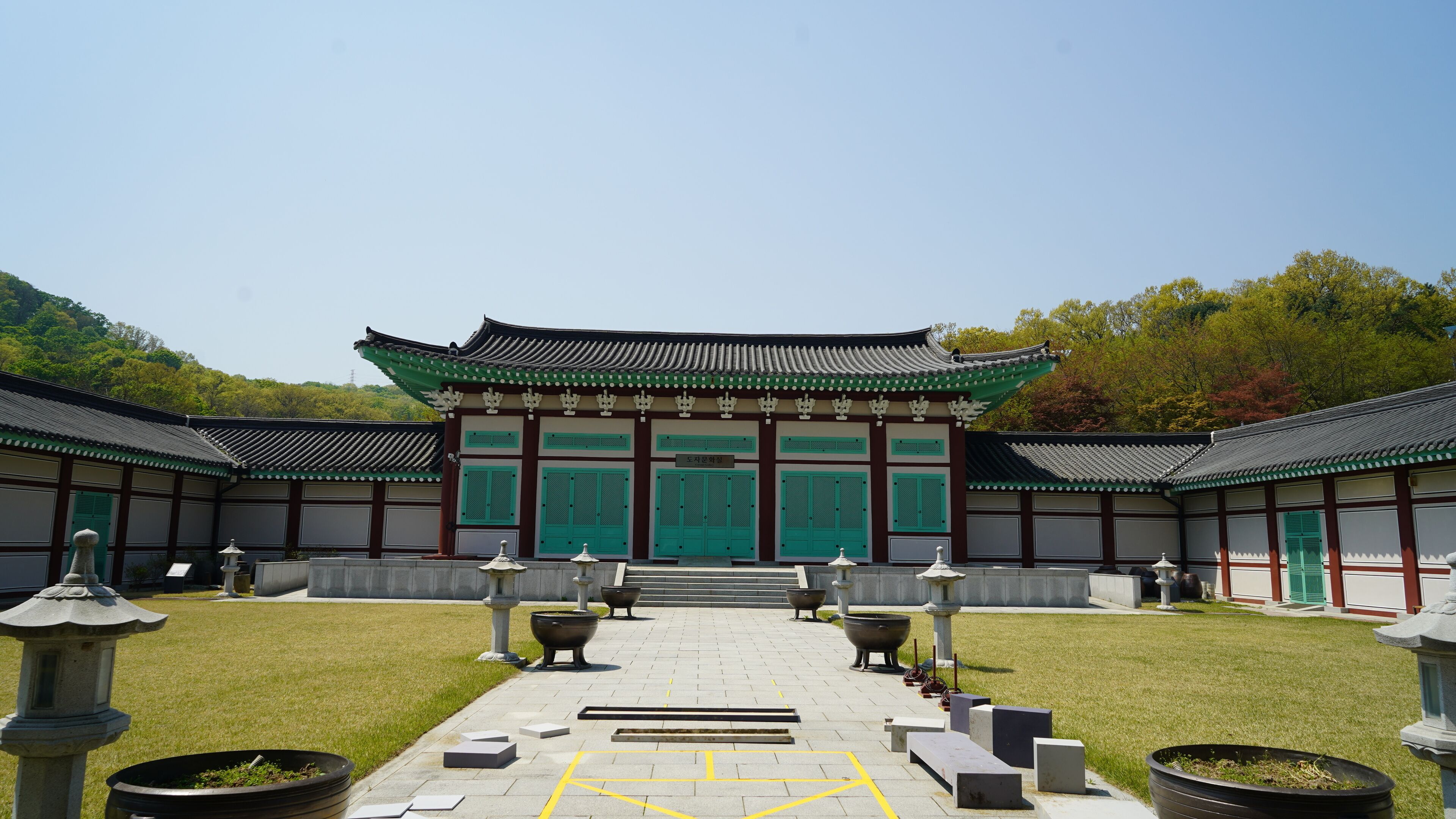 A traditional Korean temple with green doors and tiled roofs.