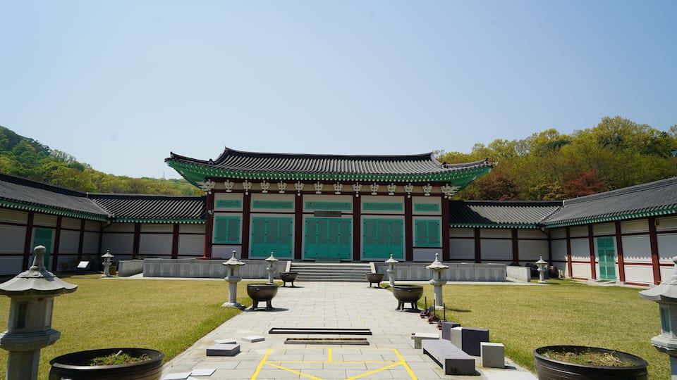 A traditional Korean temple with green doors and tiled roofs.