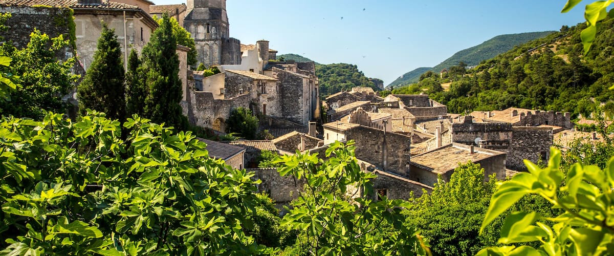 A historic town with medieval architecture, including a prominent tower and stone buildings.