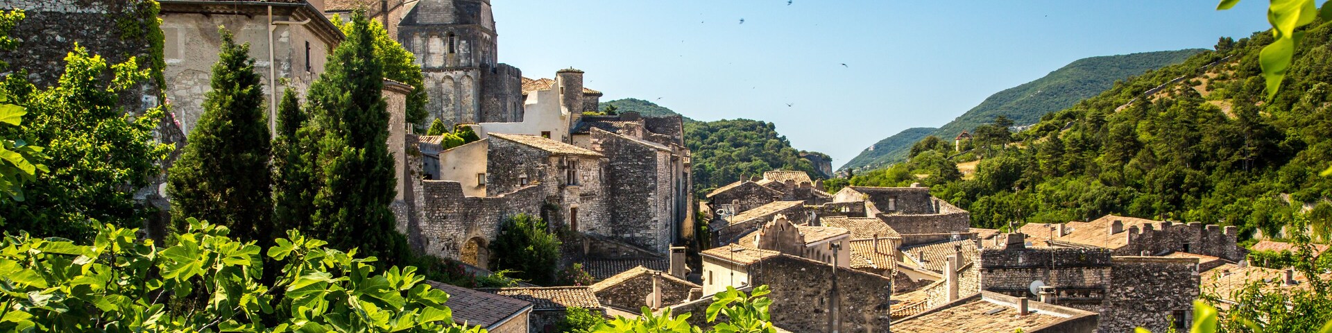 A historic town with medieval architecture, including a prominent tower and stone buildings.